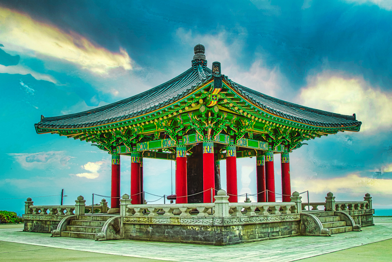 Korean Bell of Friendship — side view with the Pacific behind under a turquoise sky